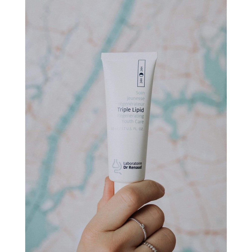 Laboratoire Dr Renaud Triple Lipid 24H restorative cream tube held in hand against a marble background