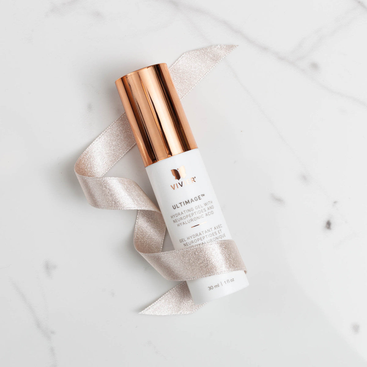 Vivier Ultimage serum bottle laid flat with visible gel texture and soft fabric background